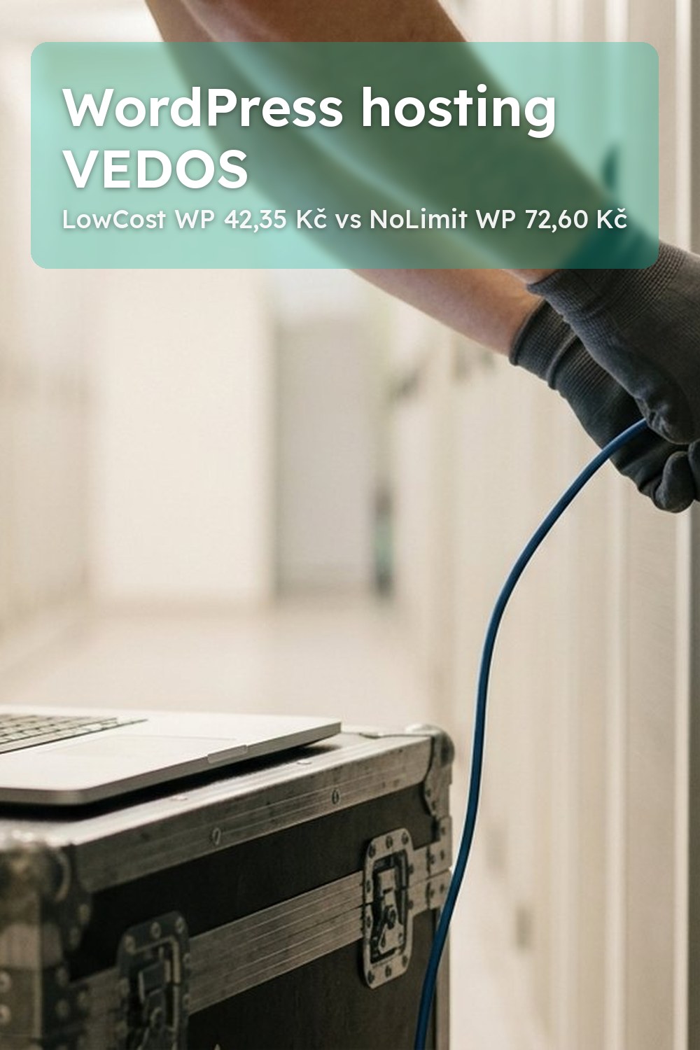 Ruce zapojují modrý síťový kabel do serveru v datovém centru, vedle notebooku s rozmazaným webem – wordpress hosting